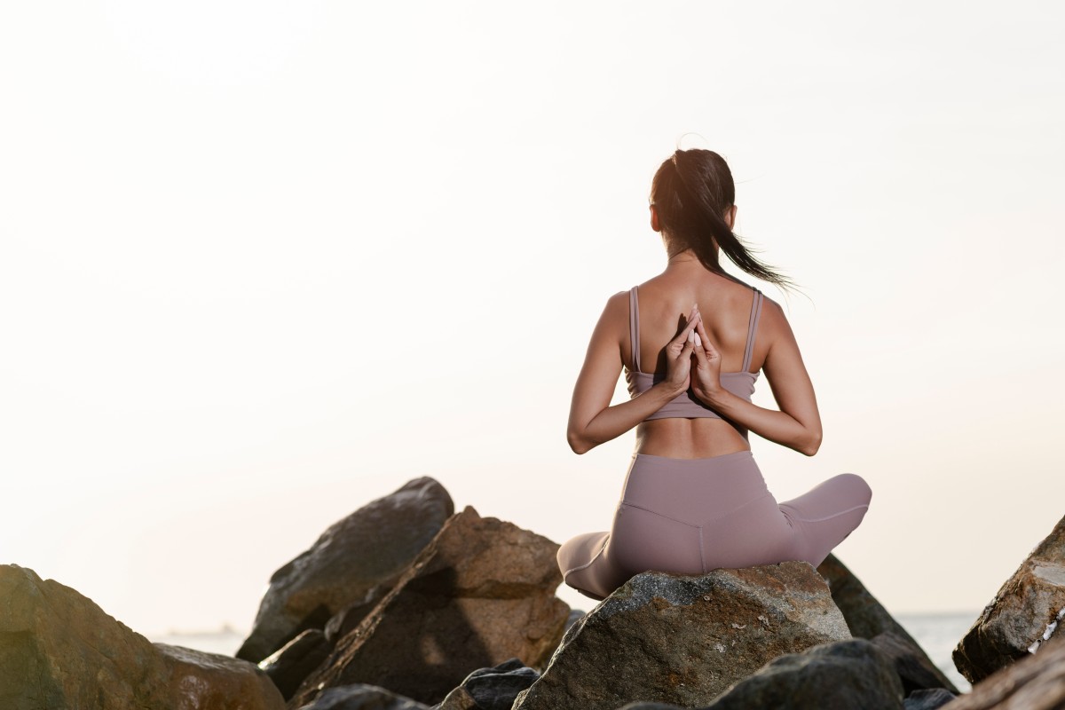 Full shot woman meditating rocks 1.jpg