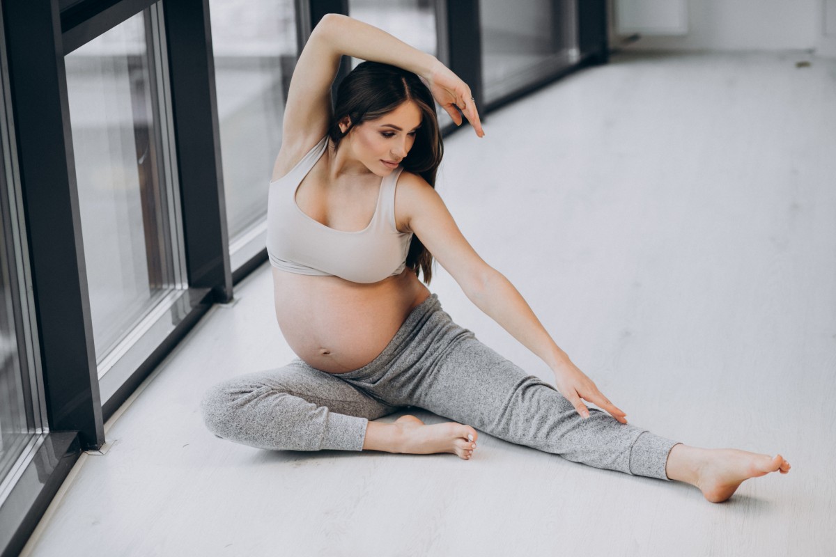 Pregnant woman practising yoga home by window 1.jpg